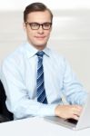 Man Sitting On Chair Using Laptop In Office Stock Photo