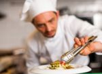 Chef Arranging Tossed Salad In A White Bowl Stock Photo