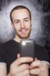 Young Male Holding Smartphone Stock Photo