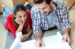 Young Couple Looking At The Blueprints Of Their New Home Stock Photo