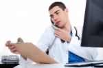 Doctor Convey His Notes To Others Over Phone Stock Photo