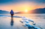 Professional Photographer With Camera On Frozen River In Winter Stock Photo