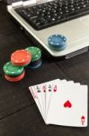 Poker Chips And Cards On A Laptop On Wooden Background Stock Photo