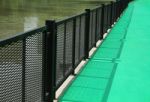 Green Walkway With Metal Fence By The Lake Stock Photo