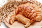 Delicious Fresh Croissants With Rice On Wooden Background Stock Photo