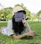 Woman Laying On Grass And Thinking In Park Stock Photo