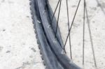 Bicycle Wheel With Flat Tyre On The Concrete Road Stock Photo