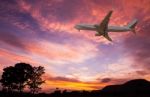 Commercial Airplane Flying At Sunset Stock Photo