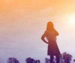 Silhouette Of Woman Praying Over Beautiful Sky Background Stock Photo