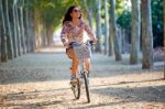 Pretty Young Girl Riding Bike In A Forest Stock Photo