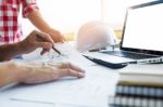 Architects Engineer Discussing At The Table With Blueprint - Clo Stock Photo