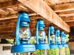 Perspective View Of Storm Lanterns Hanged On Wooden Counterpoise Stock Photo