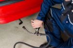 Mechanic Measuring Exhausts Of A Car In Garage Stock Photo