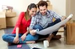 Young Couple Looking At The Blueprints Of Their New Home Stock Photo