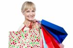 Pretty Female Carrying Shopping Bags Over Shoulders Stock Photo