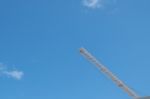 Yellow High Long Crane Arrow At Construction Site With Clear Light Blue Sky Day Stock Photo