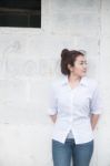 Attractive Teenage Asian Girl Standing In Front Of Grunge Concrete Wall Stock Photo