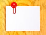 Close Up Of A  Red Paper Clip And White Paper On Wood Table Stock Photo