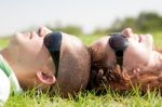 Couple Laying On Lawn Stock Photo