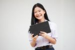 Portrait Of Thai High School Student Uniform Beautiful Girl Using Her Tablet Stock Photo