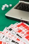 Bingo Cards On Casino Baize And A Laptop Stock Photo