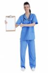 Full Length Of Young Nurse Pointing Blank Clipboard Stock Photo