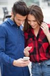 Young Couple Using Smart Phone Stock Photo