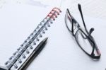 Pen, Notebook, Glasses And Financial Report Stock Photo