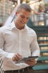 Man With Tablet Computer In Modern Business Building Stock Photo