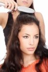 Hairdresser Combing Woman's Hair Stock Photo