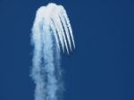 Aircrafts Drawing White Smoke Circles Into The Blue Sky Stock Photo