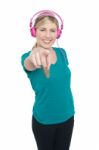 Young Girl Enjoying Music And Pointing At You Stock Photo