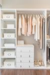 White Wardrobe On Wooden Floor With Dress Stock Photo