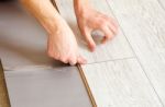 Handyman's Hands Laying Down Laminate Flooring Boards Stock Photo