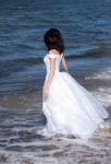 Young Girl In White Dress On The Seashore Stock Photo