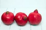 Fresh Pomegranate Fruits Isolated On A White Wooden Background Stock Photo