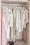 Clothes Hanging In Wooden Wardrobe Stock Photo