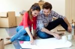 Young Couple Looking At The Blueprints Of Their New Home Stock Photo