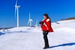 Young Woman Is A Happiness With Camera In Winter Of Sky And Winter Road With Snow And Red Dress Stock Photo