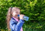 Girl Drinks Water From A Plastic Bottle Stock Photo