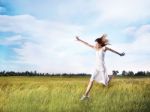 Woman Running Across Field Stock Photo