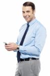 Smiling Young Manger Sending Sms From Phone Stock Photo