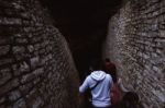 People Walking Into A Cavern Stock Photo