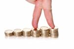 Fingers Walking Up On Stacks Of One Pound Coins Stock Photo