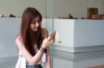 Portrait Of Thai Adult Beautiful Girl Using Her Smart Phone And Smile Stock Photo