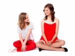 Teenage Sisters Sitting On Floor Stock Photo