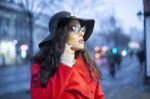 Woman In Red Coat With Smartphone In Hands Going Through The Cit Stock Photo