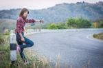 Tourist Hitchhiking Woman Standing On The Road In The Mountains Stock Photo