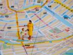 Miniature Mother And Little Girl Stand On Map. Travelling Concep Stock Photo