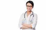 Young Pretty Female Doctor With Arms Folded Stock Photo